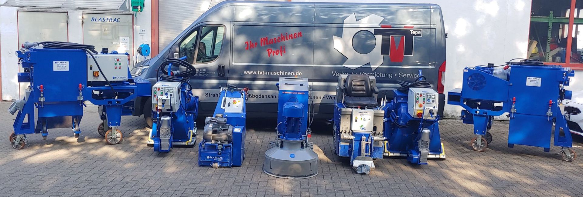 Blaue Blastrac-Maschinen zur Bodenbearbeitung vor einem Servicewagen.